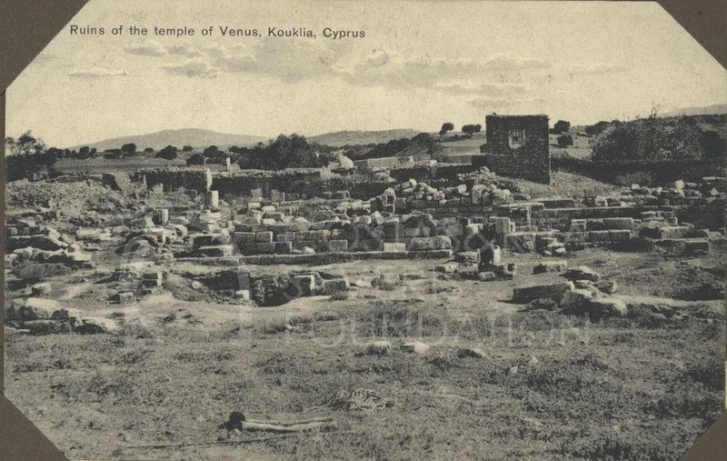 Stone blocks and low walls of the ruins of the temple of Venus at Kouklia, with hills behind