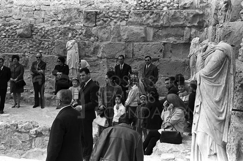 Visitors gather among ancient stone walls and draped marble statues at the Salamis site