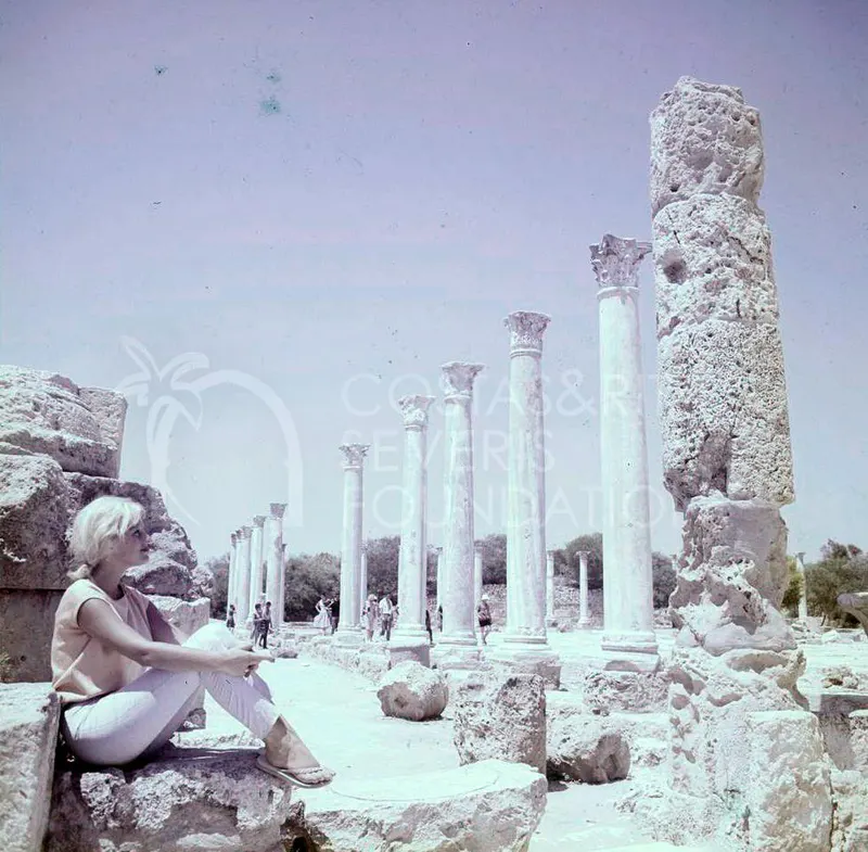 Woman seated on a stone block beside a row of columns at Salamis