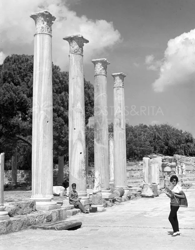 Tall fluted columns at Salamis, with a woman standing at right and a seated person at left