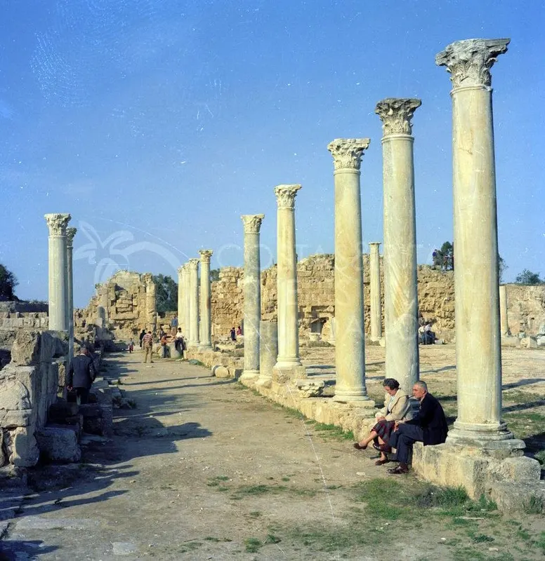 Row of tall Corinthian columns at Salamis with two people seated on a stone base at right