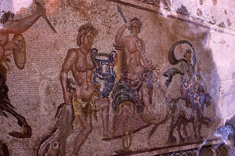 Close view of a floor mosaic with standing and mounted figures in small coloured tesserae