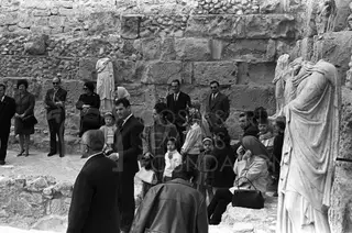 Visitors gather among ancient stone walls and draped marble statues at the Salamis site