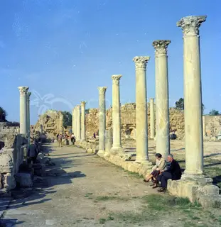 Row of tall Corinthian columns at Salamis with two people seated on a stone base at right