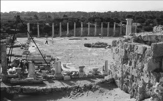 Long colonnade at Salamis with a tripod hoist and workers among fallen column drums