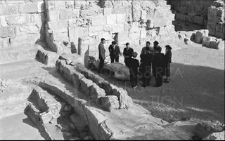 Group of people standing among ancient stone ruins at Salamis, with a large wrapped object on the ground
