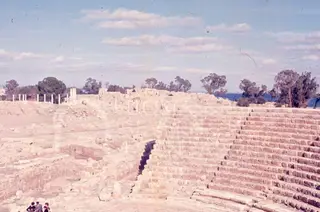 Stone tiered seating of the theatre at Salamis, with ruins, columns and the sea behind