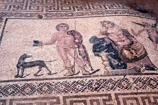Floor mosaic with a spear-bearing figure and a dog beside a draped figure, framed by geometric borders
