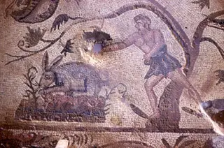 Floor mosaic detail showing a hare beside a plant and a figure in a garment among scrolling tendrils