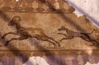 Floor mosaic of a leaping horned animal chased by a smaller dog-like animal