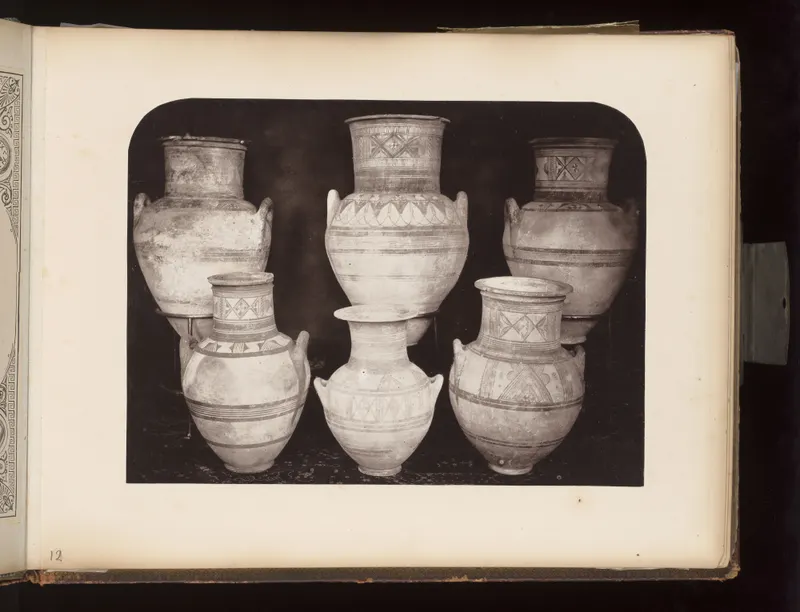 Six painted pottery vessels with handles arranged in two rows against a dark background