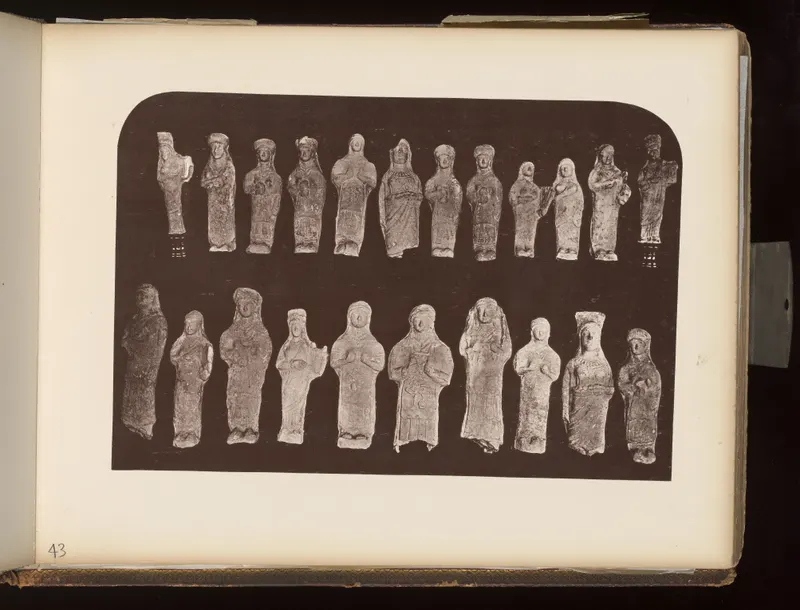 Two rows of about twenty small standing figurines laid out on a dark background