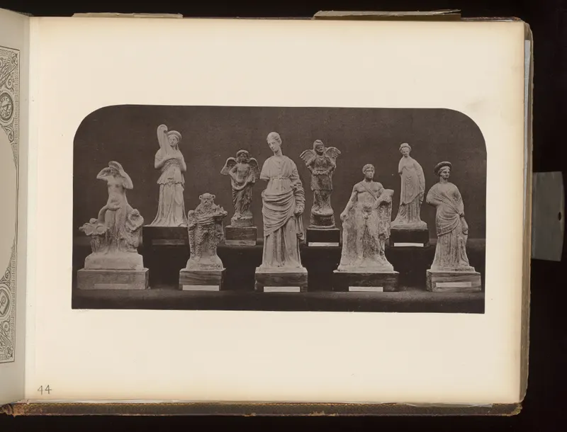 Eight small figurines of standing and seated figures on dark wooden bases, photographed against a dark background.