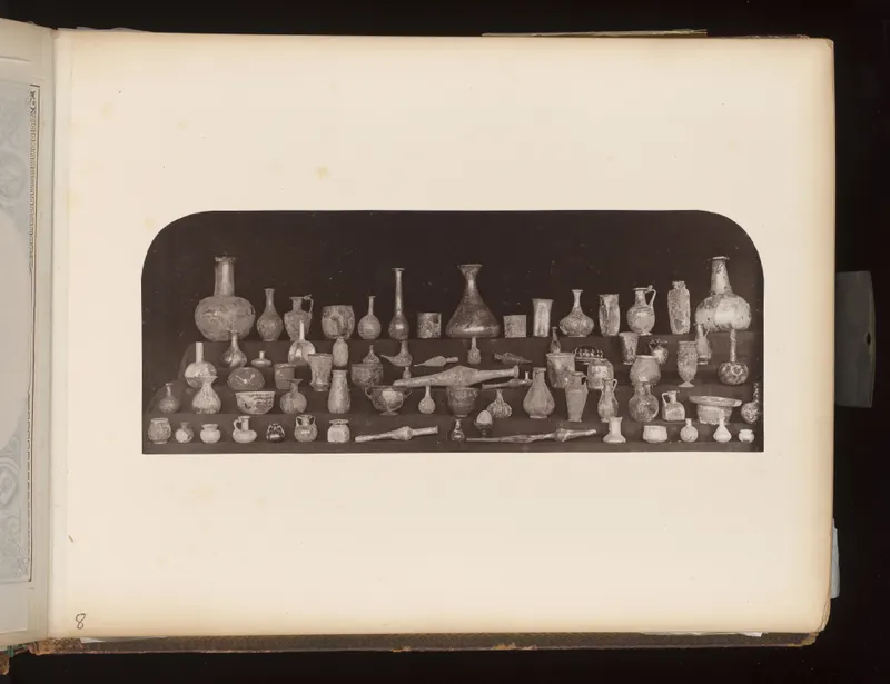 Many small vessels, bottles and jugs arranged on three tiered shelves against a dark background.