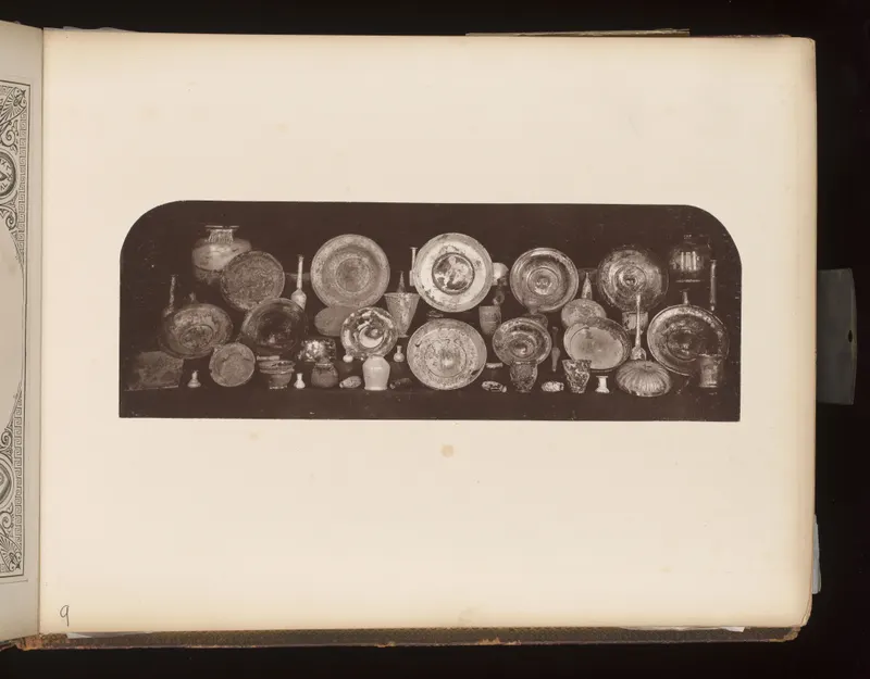 Rows of bowls, dishes, jugs and small cups set together on a dark shelf, photographed from the front.