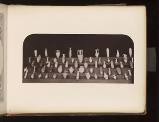 Small jugs, juglets and bottles on tiered shelves