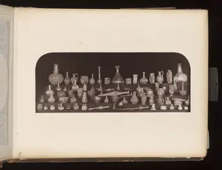 Glass vessels, bottles and jugs on tiered shelves
