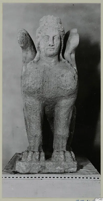 Stone statue from Soli of a winged figure with a human head, standing on a rectangular base