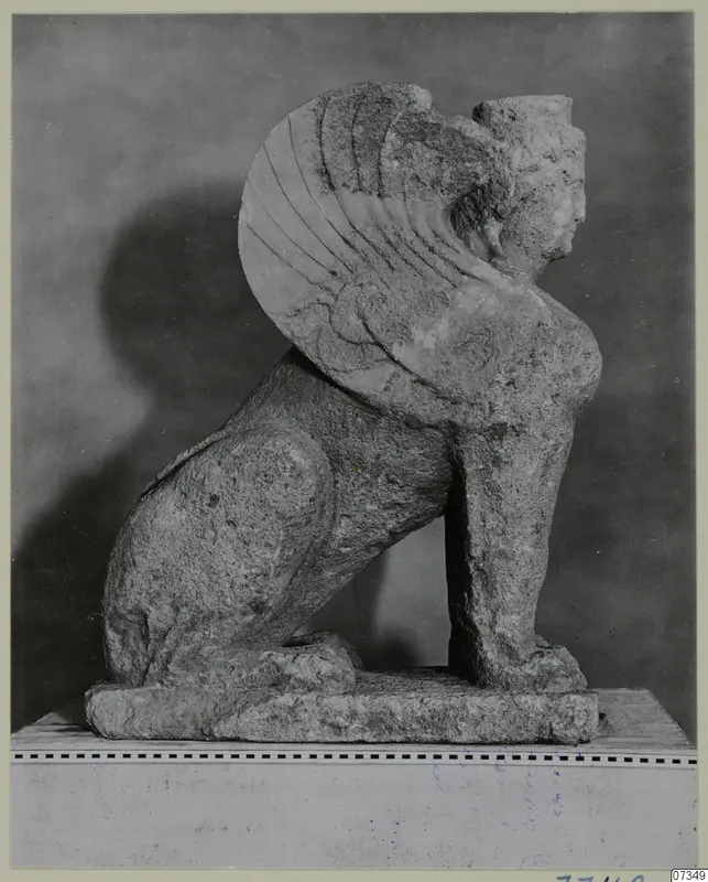 Stone statue of a seated winged creature with a human face, from Soli