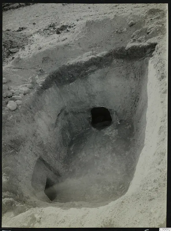 Tomb 314 at Lapithos during excavation, with the tomb chamber opening visible in the cut face