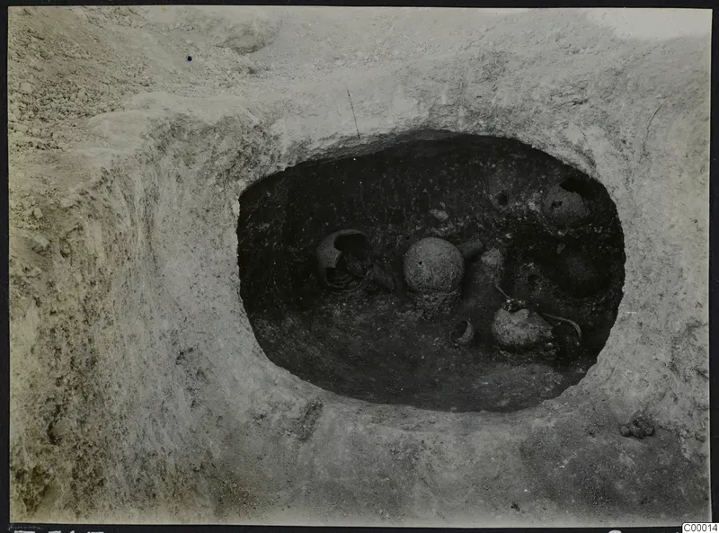 Tomb 305 at Lapithos seen from above during excavation, with pottery vessels lying inside the tomb chamber.