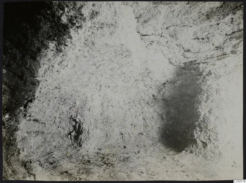 Interior of Tomb 302 at Vrysi tou Barba, Lapithos, during excavation, showing a rough pale surface and shadowed hollows.