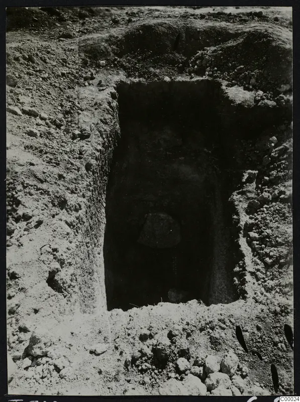 Tomb 308 at Lapithos, Vrysi tou Barba, during excavation, showing a rectangular tomb opening cut into the soil with a stone inside.