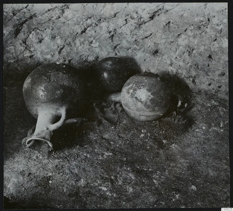 Three pottery vessels lying in the tomb chamber at Lapithos, Vrysi tou Barba, during excavation.