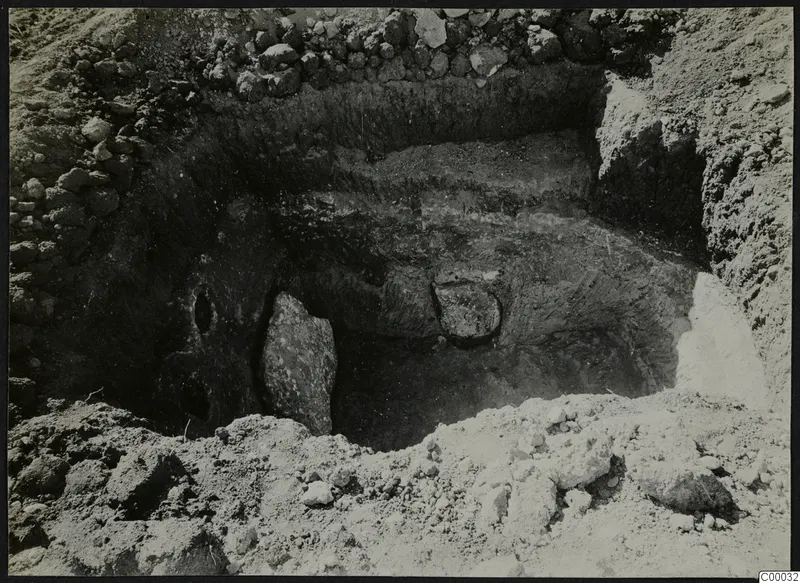 Tomb 311 at Lapithos, Vrysi Tou Barba, during excavation, showing an upright stone slab and stones in the chamber