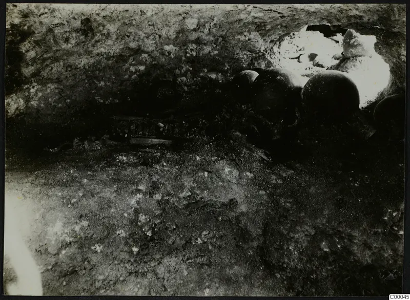Tomb 313 b at Vrysi tou Barba, Lapithos: interior of a tomb chamber with dark vessels, during excavation