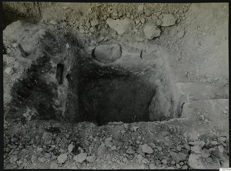 Tomb 316 at Lapithos, Vrysi tou Barba, during excavation, showing the open tomb chamber among loose stones.