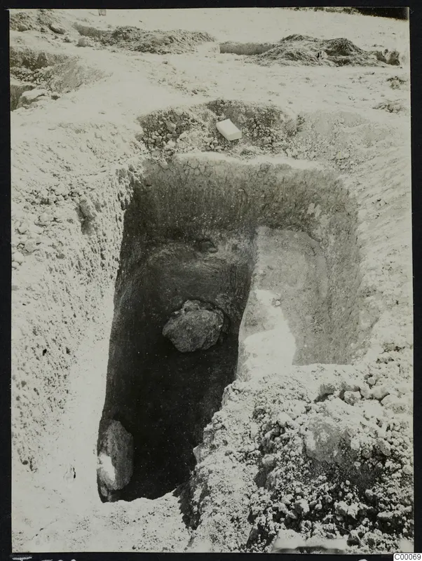 Excavated tomb 308 at Lapithos, Vrysi tou Barba, with a large stone inside the chamber and a pale box on the spoil above it