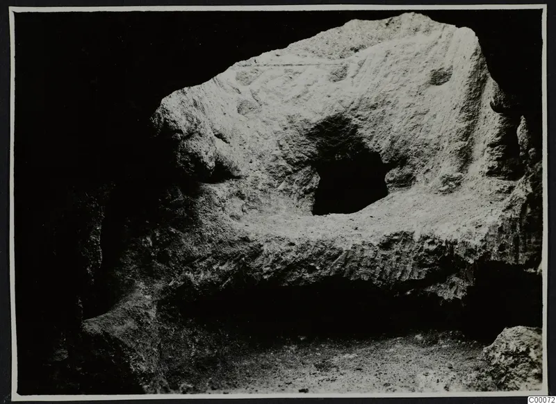 Rock-cut surface of Tomb 306 at Lapithos, Vrysi tou Barba, during excavation, with a small dark opening