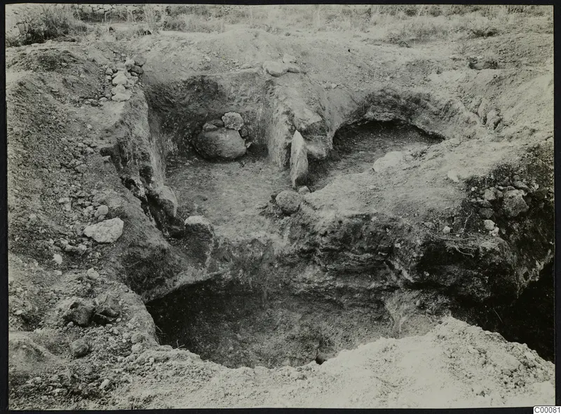 Excavated tombs 320 and 323 at Vrysi tou Barba, Lapithos, with cut earth sides and stones on the floor
