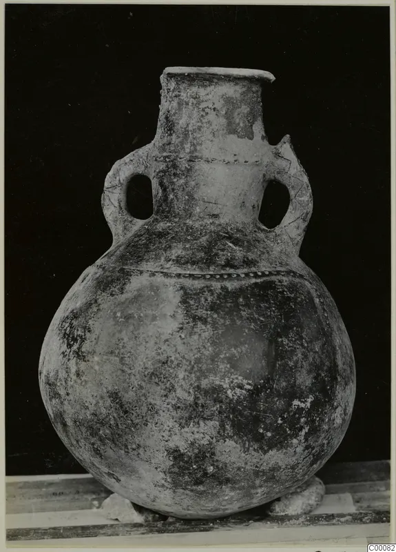 Pottery Red Polished III amphora with two loop handles and a wide round body, shown against a dark background.