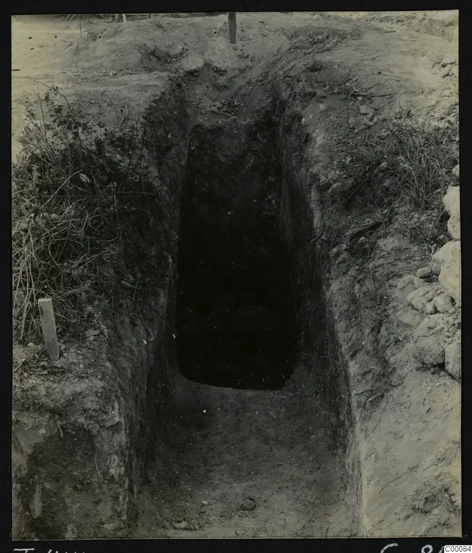 Tomb 414 at Lapithos during excavation, a steep cut passage leading down to a dark tomb chamber opening