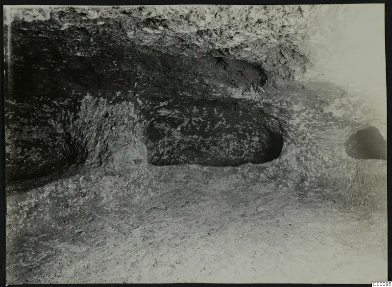 Interior of tomb chamber at Vrysi tou Barba, Lapithos, with rock-cut hollows in the walls during excavation