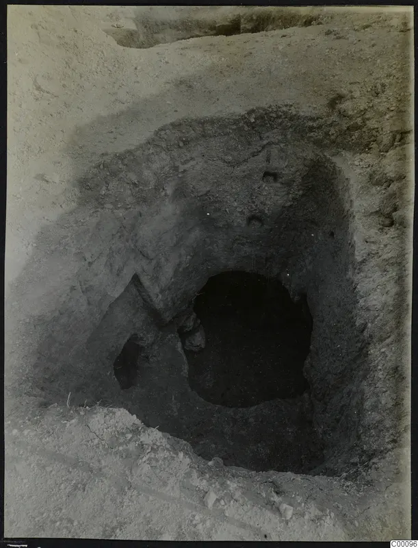 Tomb 306 at Lapithos, Vrysi tou Barba, during excavation, showing the dark opening of the tomb chamber in the excavated soil