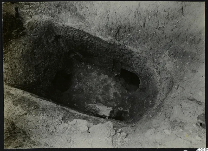 Tomb 312 at Lapithos, Vrysi tou Barba, during excavation, showing the open tomb chamber with a large stone inside.