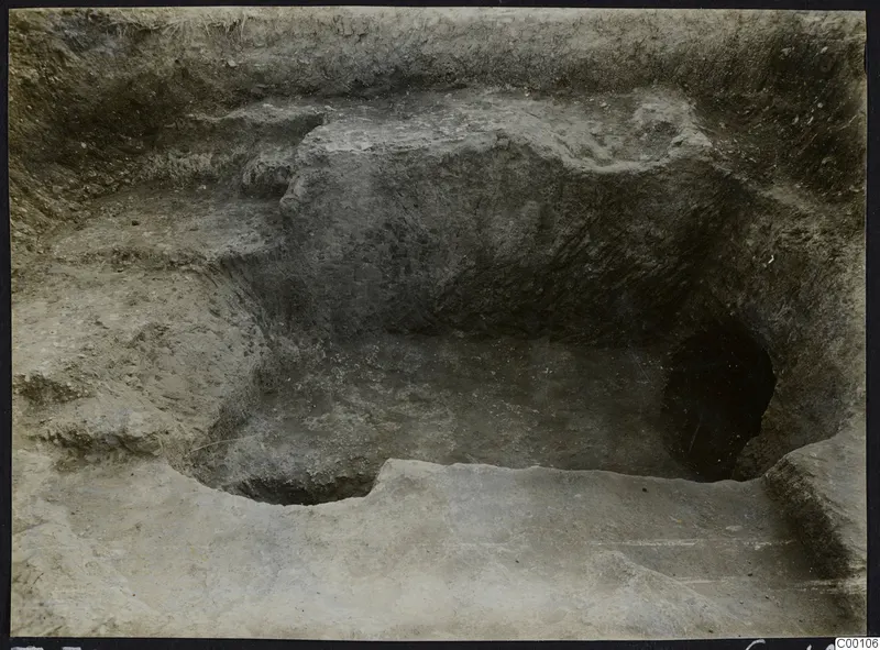 Excavated tomb at Vrysi tou Barba, Lapithos, with a dark opening in the cut rock face during excavation