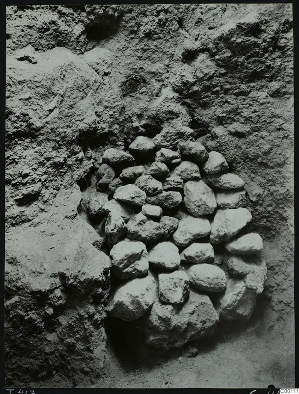 Stones packed into the doorway of Tomb 417 at Lapithos, set into a rough earthen cut face.