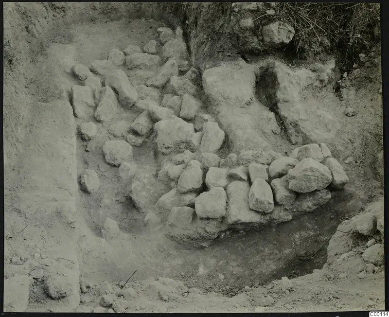 Tomb 412 at Lapithos Kastros during excavation, with rough stones set in an excavated cut