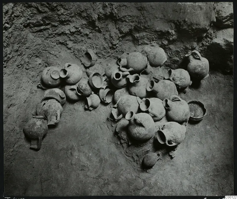 Pottery vessels lying in situ on the earth floor of Tomb 417 at Lapithos, against the rock wall of the chamber