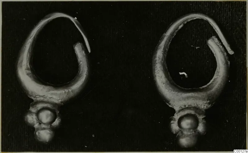 Two gold loop earrings with knob-shaped pendants, shown side by side on a black background