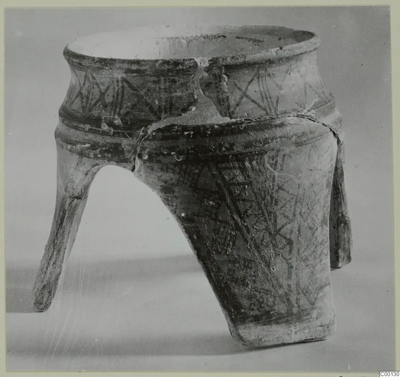 Tripod pottery vessel from Lapithos, White Painted I, with dark painted bands and three splayed legs