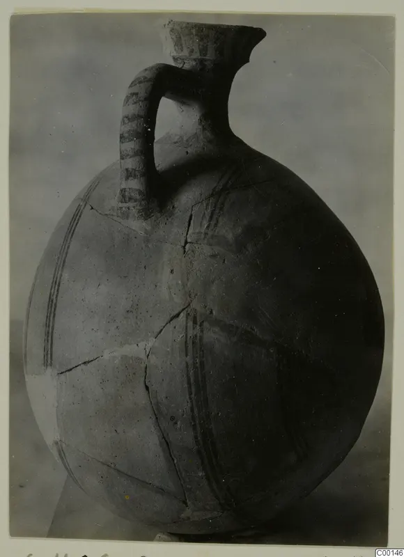 White Painted I jug from Lapithos, with a loop handle, tall neck and dark painted bands, mended cracks visible