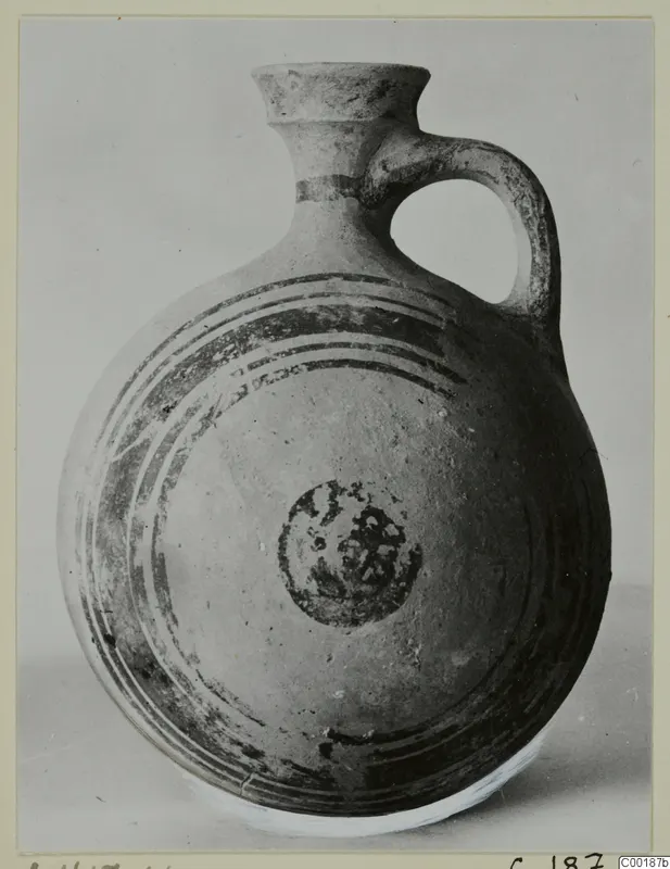 White Painted I jug with a flared neck, single loop handle and dark concentric bands on the body