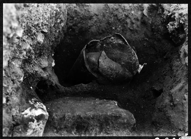 Broken vessel lying in an excavated cutting at Soli, with a stone block in the foreground