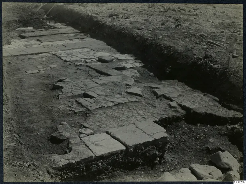 Excavated stone paving or floor at Soli, with flat slabs and smaller stones set in a trench