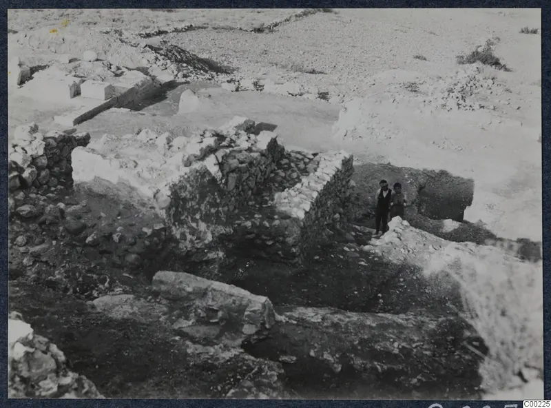 Excavated stone walls at the theatre at Soli, with two people standing among the ruins.